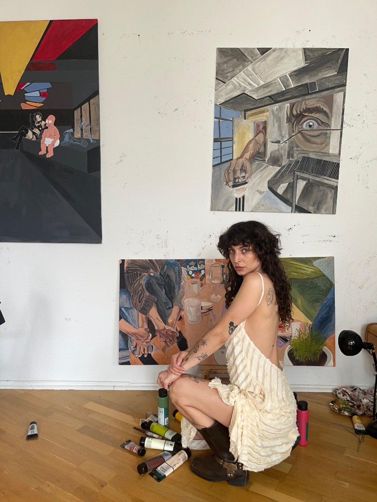 ANANI in her studio surrounded by paintings